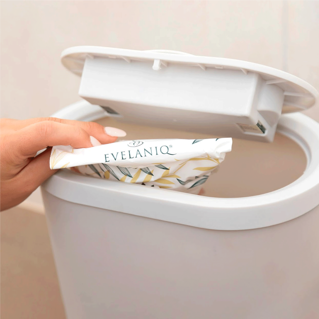 close-up photo: disposing of a sealed Evelaniq sanitary bag into the bin. No odours, no mess, just clean hygiene at home.